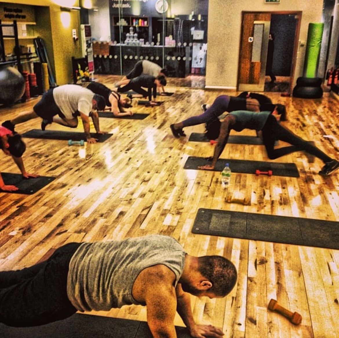 Small-group conditioning class in a Birmingham gym studio, mid-session, coached by Coach Spartan